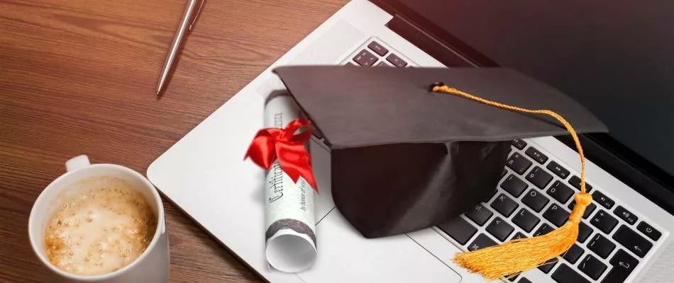 Accreditation in online middle school education symbolized by a graduation cap and diploma on a laptop keyboard.
