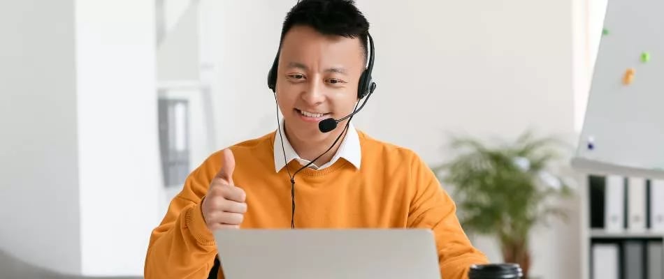 Choosing an online middle school program with live virtual support from a smiling educator giving a thumbs-up.