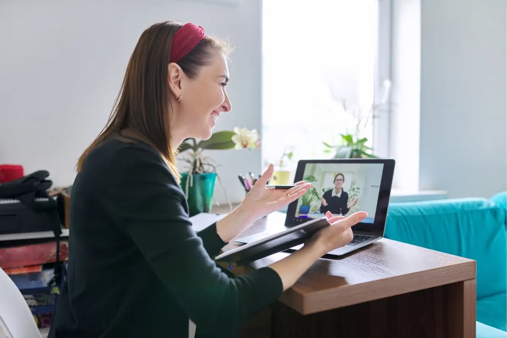 Virtual learning session with a woman engaging in a video call on her laptop at home
