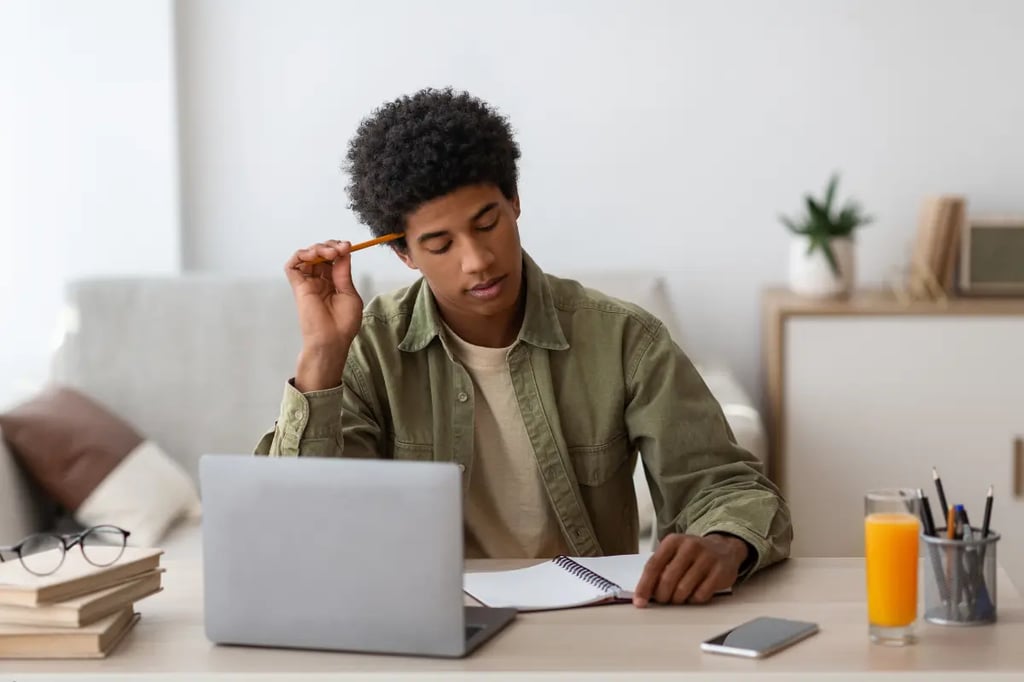 Online middle school student studying with a laptop and notebook in a cozy home environment