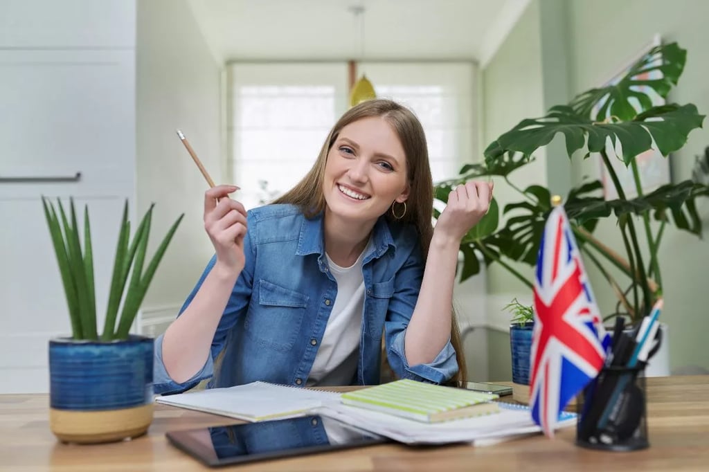 Benefits of student-centered learning shown through a smiling student studying with UK flag, books, and plants on a desk.