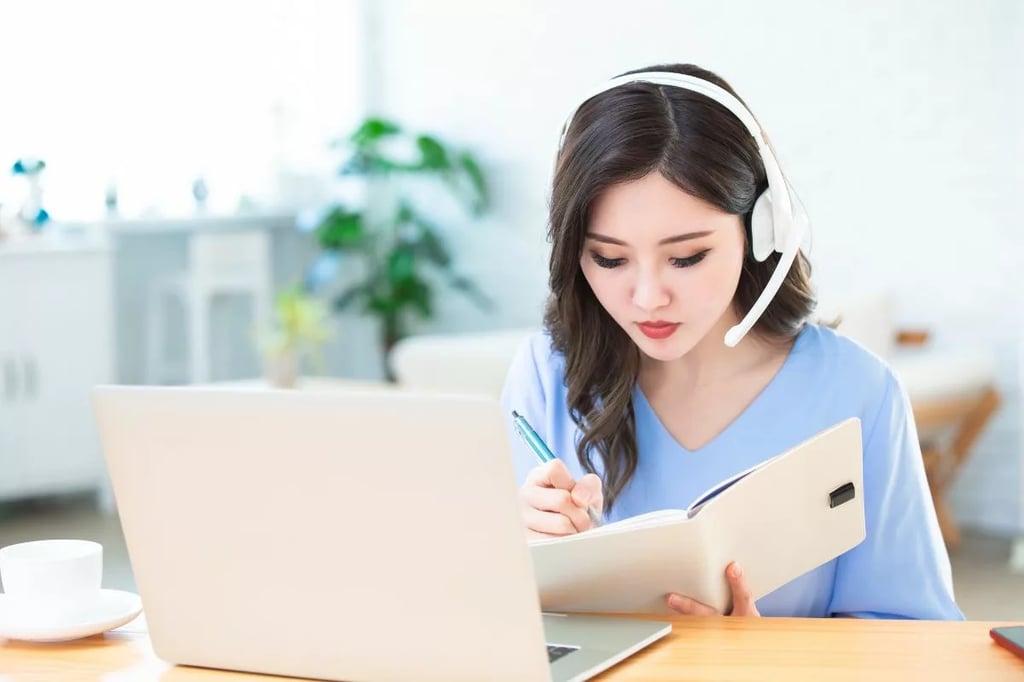 Best homeschool curriculum illustrated by a focused student with a headset studying from a laptop and writing in a notebook.