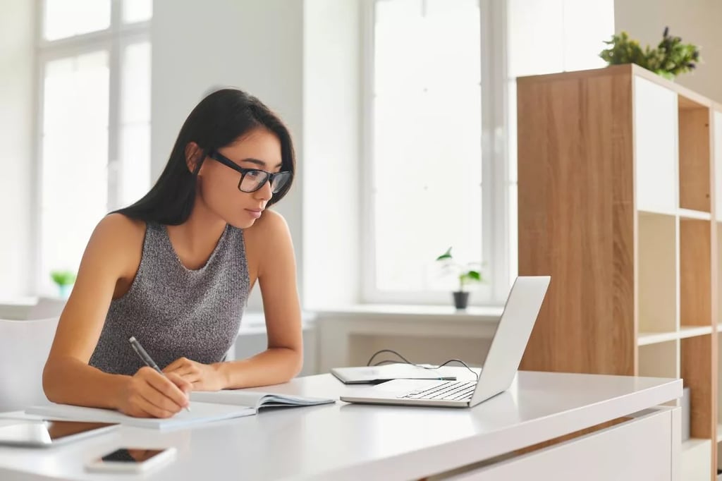 Student-centered approach illustrated by a focused young woman studying with a laptop and notebook in a bright, modern space.