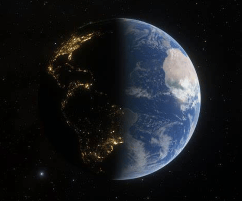 A stunning view of Earth from space, showing a division between night and day with city lights illuminating the dark side.
